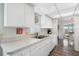 Well-lit kitchen with white cabinetry, modern appliances, and a view of the dining area at 550 Tampico Dr, North Port, FL 34287
