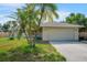 Charming single-story home with mature palm trees, a well-manicured lawn, and an attached two-car garage at 5639 Blount Ave, Sarasota, FL 34231