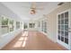 Bright sunroom with wood-look floors, many windows, and white ceiling fans at 5639 Blount Ave, Sarasota, FL 34231