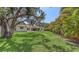 Expansive backyard featuring lush green grass and mature trees, perfect for outdoor enjoyment at 5698 Country Walk Ln, Sarasota, FL 34233