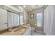 Well-lit bathroom featuring tile floors, a framed mirror, and a shower with a white curtain at 5698 Country Walk Ln, Sarasota, FL 34233
