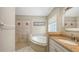 Bathroom featuring vanity with neutral countertops, soaking tub, and tiled shower at 5698 Country Walk Ln, Sarasota, FL 34233
