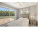 Serene bedroom with view to lush backyard, featuring sliding glass door and a stylish bedside table at 5698 Country Walk Ln, Sarasota, FL 34233