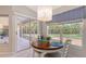 Dining area with chandelier, window, and slider to a screened lanai at 5698 Country Walk Ln, Sarasota, FL 34233