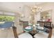 Spacious dining area features a glass table, wicker chairs, and a nearby living area for easy entertaining at 5698 Country Walk Ln, Sarasota, FL 34233
