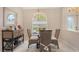 A sunlit dining room with wicker chairs and a glass table offers a charming space for meals and gatherings at 5698 Country Walk Ln, Sarasota, FL 34233