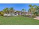 Beautiful home with a well-manicured lawn, mature landscaping, and palm trees, offering great curb appeal at 5698 Country Walk Ln, Sarasota, FL 34233