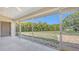 Screened lanai with a serene view of the lush backyard and pond at 5698 Country Walk Ln, Sarasota, FL 34233