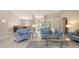Spacious living room with glass coffee table, chandeliers, and a dining area in the background at 5698 Country Walk Ln, Sarasota, FL 34233
