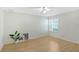 Simple bedroom with a ceiling fan, hard wood floors, large window and decor at 5787 Ivrea Dr, Sarasota, FL 34238
