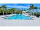 Inviting lap pool with clear blue water surrounded by mature trees and lounge seating at 5787 Ivrea Dr, Sarasota, FL 34238