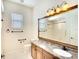 Bright bathroom featuring granite countertops, a large framed mirror, and tiled shower at 5905 32Nd E St, Ellenton, FL 34222