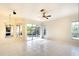 Bright living room with tile floors, a ceiling fan, and large windows overlooking the landscaped backyard at 5905 32Nd E St, Ellenton, FL 34222