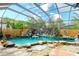 Enclosed pool area featuring rock waterfall and lush landscaping at 5905 32Nd E St, Ellenton, FL 34222