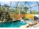 Tranquil pool with rock features and lush tropical landscaping in a screened enclosure at 5905 32Nd E St, Ellenton, FL 34222