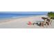 Inviting beach scene with lounge chairs, umbrella, and clear turquoise waters at 631 N Orange Ave # 208, Sarasota, FL 34236