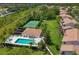 Aerial view showcasing pool, tennis court, clubhouse, and lush landscaping in this desirable community at 6335 Bay Cedar Ln, Bradenton, FL 34203
