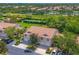 An aerial view shows the condo's location near a tennis court, a lake, and surrounded by lush greenery and well manicured lawns at 6335 Bay Cedar Ln, Bradenton, FL 34203
