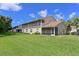 View of the home's screened-in patios overlooking a green backyard at 6335 Bay Cedar Ln, Bradenton, FL 34203