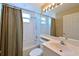 Bathroom with a shower and tub combination with a striped shower curtain and large mirror at 6335 Bay Cedar Ln, Bradenton, FL 34203