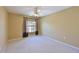 Neutral bedroom featuring a ceiling fan, window with dark curtains, and light carpet at 6335 Bay Cedar Ln, Bradenton, FL 34203