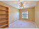 Bedroom featuring a ceiling fan, window with light curtains, and light carpet, with shelving at 6335 Bay Cedar Ln, Bradenton, FL 34203