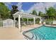 Community pool featuring a pergola with seating and a safety fence at 6335 Bay Cedar Ln, Bradenton, FL 34203