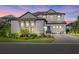 Elegant two-story home featuring a manicured lawn, beautiful landscaping, and well-lit exterior at 6349 Isla Del Ray Ave, Sarasota, FL 34240