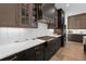 The kitchen area features an island with a white countertop, marble backsplash, and black cabinets at 6349 Isla Del Ray Ave, Sarasota, FL 34240