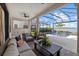 Covered lanai featuring comfortable seating, ceiling fan, and waterfront views with screened enclosure at 6349 Isla Del Ray Ave, Sarasota, FL 34240