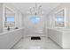 Bright main bathroom equipped with double vanities, large mirrors, and a glass walk-in shower with marble floors at 6349 Isla Del Ray Ave, Sarasota, FL 34240