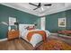 Beautifully decorated main bedroom features a ceiling fan, hardwood floors, and a green accent wall at 6349 Isla Del Ray Ave, Sarasota, FL 34240