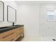 A modern bathroom with double sinks, dark fixtures and hardware, and a shower with marble-look tile at 6572 Mauna Loa Blvd, Sarasota, FL 34241