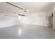 Open garage space featuring speckled flooring, a water heater, and a side door at 6572 Mauna Loa Blvd, Sarasota, FL 34241