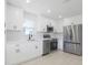 Modern kitchen with white cabinets, stainless steel appliances, and plenty of counter space, creating a clean and functional design at 6572 Mauna Loa Blvd, Sarasota, FL 34241
