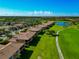 Aerial view of the neighborhood showcasing lush landscaping, well-maintained homes, a golf course, and several ponds at 7106 Grand Estuary Trl # 102, Bradenton, FL 34212