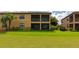Well-maintained backyard featuring a lush lawn and a view of the home's screened lanai, perfect for outdoor activities at 7106 Grand Estuary Trl # 102, Bradenton, FL 34212