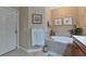 Well-lit bathroom features a soaking tub, neutral tile, and decorative artwork at 7106 Grand Estuary Trl # 102, Bradenton, FL 34212