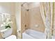 Bathroom featuring tub with shower and neutral-toned tiles at 7106 Grand Estuary Trl # 102, Bradenton, FL 34212