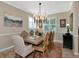 Dining room with a large table, ornate chairs, modern chandelier, and a view of the outdoors at 7106 Grand Estuary Trl # 102, Bradenton, FL 34212