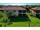 Back exterior view of two-story home featuring a lawn, trees and screened-in lanais at 7106 Grand Estuary Trl # 102, Bradenton, FL 34212