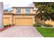 Exterior view of a home with a brick driveway, two-car garage and well-maintained landscaping at 7106 Grand Estuary Trl # 102, Bradenton, FL 34212