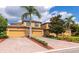 Charming home featuring a tile roof, brick driveway and lush landscaping at 7106 Grand Estuary Trl # 102, Bradenton, FL 34212