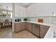 Kitchen with white and brown cabinets, stainless steel dishwasher, and decorative backsplash at 7106 Grand Estuary Trl # 102, Bradenton, FL 34212