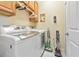 Bright laundry room with modern washer and dryer units and cleaning supplies at 7106 Grand Estuary Trl # 102, Bradenton, FL 34212