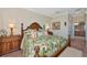 Bedroom with wooden bed frame, bedside tables, patterned bedding, and view into bathroom at 7106 Grand Estuary Trl # 102, Bradenton, FL 34212