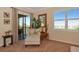 Sitting area with white lounge chair and access to screened outdoor space with golf course view at 7106 Grand Estuary Trl # 102, Bradenton, FL 34212