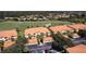 Aerial view of condos in a golf course community with tile roofs, mature trees, and well-maintained landscaping at 7155 Boca Grove Place Pl # 202, Lakewood Ranch, FL 34202