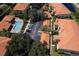 Aerial view of the community featuring a pool, parking, lush landscaping, and red tile roofs at 7155 Boca Grove Place Pl # 202, Lakewood Ranch, FL 34202