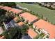 Aerial view of condos with tile roofs situated near golf course and lush green spaces, along with ample parking at 7155 Boca Grove Place Pl # 202, Lakewood Ranch, FL 34202